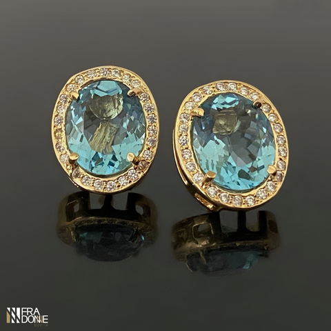 Brincos com cristais em tom de azul em formato oval, detalhes em zircônias, banho a ouro 18k