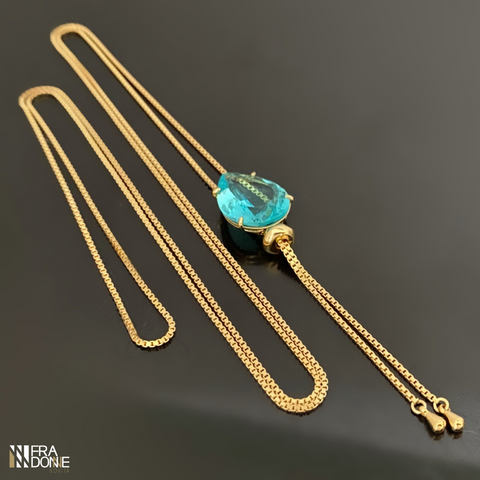 Colar longo modelo gravata, com cristal em tom de azul aquamarine, banho a ouro 18k
